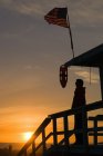 Silhouette de l'homme sur la plage au coucher du soleil — Photo de stock