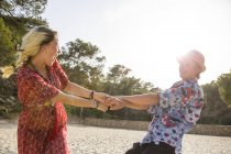 Couple holding hands spinning around, Majorca, Spain — Stock Photo