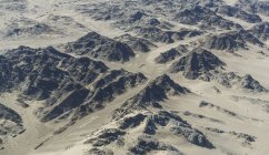 Vista aérea sobre montañas rocosas y valles a la luz del sol - foto de stock
