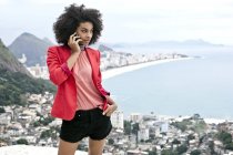 Молодая женщина с помощью мобильного телефона, Casa Alto Vidigal, Рио-де-Жанейро, Бразилия — стоковое фото