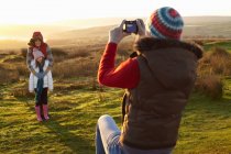 Женщина фотографирует семью на открытом воздухе — стоковое фото
