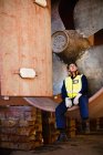 Worker sitting in propeller on dry dock — Stock Photo