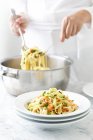 Cook mixing linguini pasta — Stock Photo
