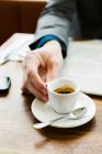 Businessman drinking cappuccino, close-up partial view — Stock Photo