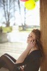 Teenage girl talking on mobile at birthday party — Stock Photo