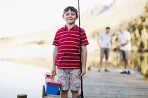 Niño llevando caña de pescar en embarcadero - foto de stock