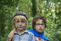 Портрет двух мальчиков в лесу с краской на лице — стоковое фото