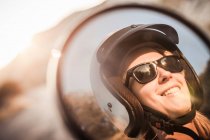 Mulher usando capacete de moto e óculos de sol — Fotografia de Stock