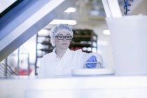 Factory worker wearing hair net in food production factory — Stock Photo