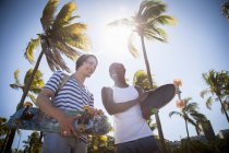 Two men, holding skateboards, walking outdoors — Stock Photo