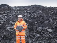 Портрет шахтера, держащего уголь в шахте — стоковое фото