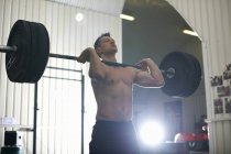 Hombre adulto medio levantando barra en el gimnasio - foto de stock