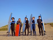 Cinco surfistas adolescentes em uma praia — Fotografia de Stock