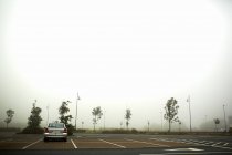 Voiture garée dans le parking brumeux — Photo de stock