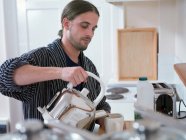 Чоловік робить чашку чаю на кухні — стокове фото