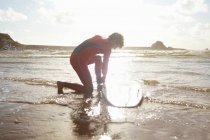 Чоловічий серфер, що не друкує дошку для серфінгу з щиколотки — стокове фото