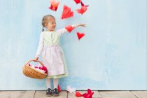 Lächelndes Mädchen, das mit Papierblumen spielt — Stockfoto