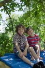 Мальчики сидят на крыше домика на дереве — стоковое фото