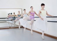 Balletttänzer posieren am Barre — Stockfoto