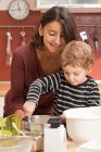 Mãe e filho cozinhar na cozinha — Fotografia de Stock