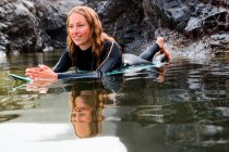 Frau liegt auf Surfbrett im Wasser — Stockfoto
