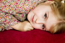 Smiling girl laying on pillow — Stock Photo