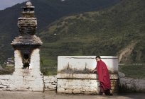 Porträt eines jungen buddhistischen Mönchs, der am Tempelbrunnen trinkt, Punakha, Bhutan — Stockfoto