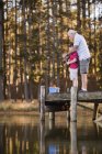 Boy fishing with grandfather in lake — Stock Photo