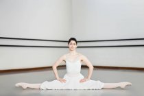 Ballet dancer doing splits in studio — Stock Photo