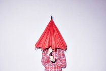Mulher segurando guarda-chuva vermelho sobre a cabeça — Fotografia de Stock
