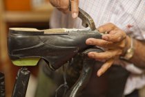 Cobbler mending sole of shoe — Stock Photo