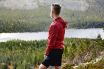 Rear view of sporty man overlooking landscape, Lapland, Finland — Stock Photo