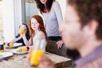 Mädchen beobachtet Vater beim Orangensaft trinken — Stockfoto