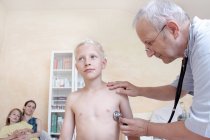 Menino sendo examinado por médico com estetoscópio — Fotografia de Stock