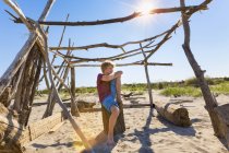 Хлопчик робить перерву в driftwood притулок, Caleri пляж, Венето, Італія — стокове фото