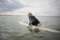 Пожилая женщина на доске для серфинга в море, паддлбординг — стоковое фото