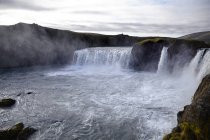 Landscape view of waterfalls under cloudy sky — Stock Photo