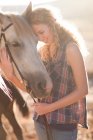 Молода жінка торкається обличчя коня — стокове фото