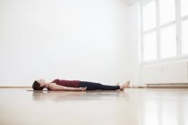 Жінка в студії вправ лежить на спині на підлозі — стокове фото