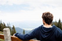Mann sitzt auf Bank und beobachtet Landschaft — Stockfoto