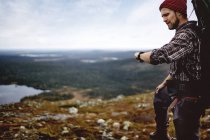 Hiker with backpack checking time, Lapland, Finland — Stock Photo