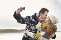 Середині дорослих пара беручи Автопортрет з смартфон на пляжі, Bloemendaal aan Zee, Нідерланди — стокове фото