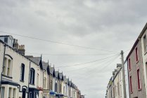 Vista ad angolo basso di case a schiera con palo telegrafico e fili, Maryport, Cumbria, Regno Unito — Foto stock