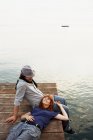Couple resting on jetty — Stock Photo