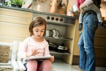 Mädchen nutzt digitales Tablet in Küche — Stockfoto