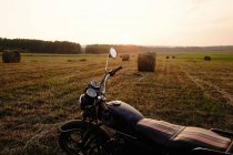 Moto parcheggiata in campo al tramonto, Ural, Russia — Foto stock