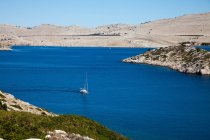 Sailboat on vivid blue water of still lake — Stock Photo