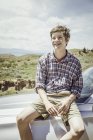 Porträt eines Teenagers, der auf der Motorhaube eines Geländewagens sitzt, Bridger, Montana, USA — Stockfoto