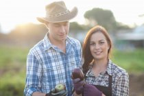 Young farm workers with aubergines grown on farm — Stock Photo