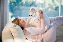 Frau entspannt sich, spielt mit Hund — Stockfoto